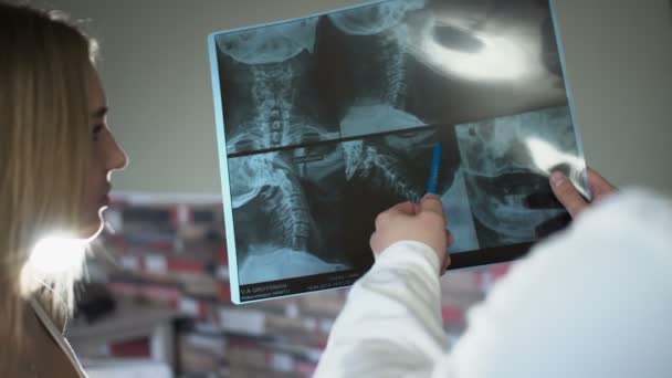 Bald adult 30s doctor is showing x-rays to a patient and discuss it — Stock Video