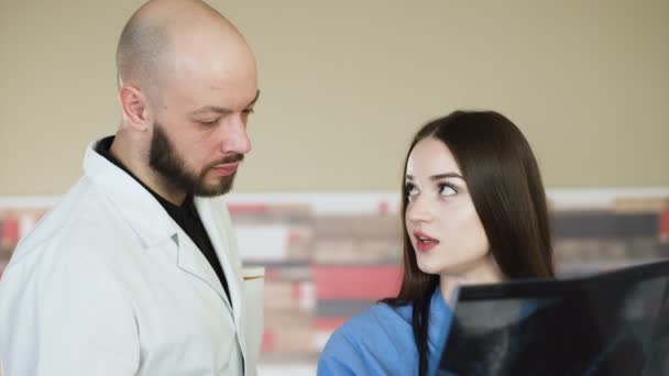 Equipo médico mirando rayos X juntos en el hospital discutir 4k — Vídeos de Stock