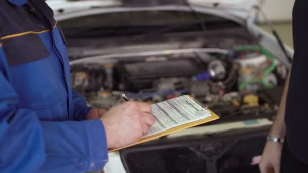 Gros plan des mains client du service de réparation automobile donne des clés au mécanicien automobile avec presse-papiers et serrer la main — Video