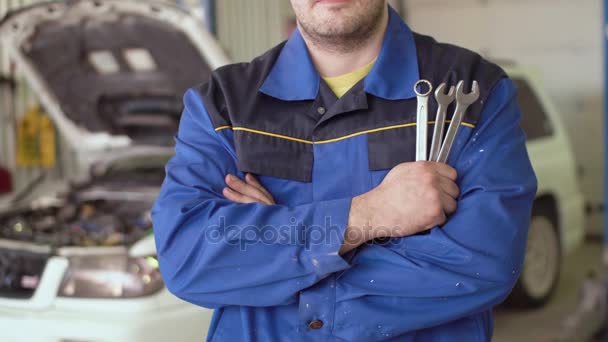 Konzeptporträt eines Automechanikers, der mit einem Schraubenschlüssel die Hände kreuzt — Stockvideo