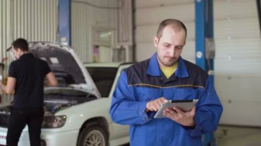 Araba tamircisi bir araba cepair hizmette tablet dokunmatik ekranın kullanılması