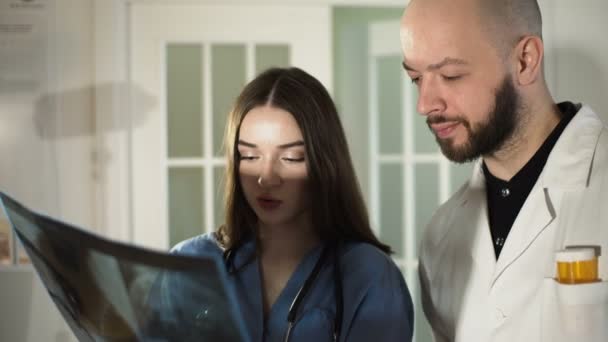 Equipe médica olhando para raio-x juntos no hospital discutir 4k — Vídeo de Stock