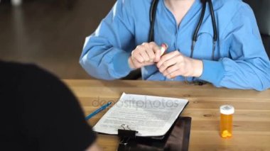genç kadın doktor hap ve turuncu kavanoza uyuşturucu veriyor. ahşap masa 4 k kapat