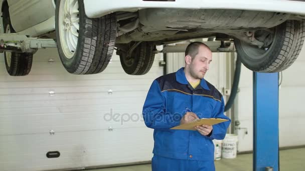 Mecánico del coche está comprobando la suspensión del coche en crossover en el servicio de reparación de automóviles — Vídeos de Stock