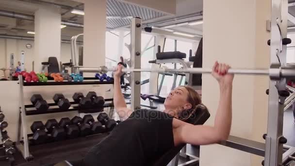 20s mulher atlética feminina em sportswear preto está levantando barbell em um ginásio — Vídeo de Stock