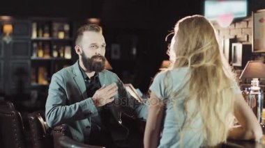 Gece barda konuşuyor arkadaş şirket. Kızıl saçlı kadın beşlik sakallı onun arkadaşı veriyor içinde bar, sonra onlar gözlük birlikte tıklatması.