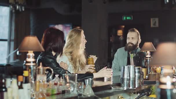 Companhia de 3 amigos positivos felizes comemorando no bar da noite, copos de clink e diversão conversando juntos — Vídeo de Stock