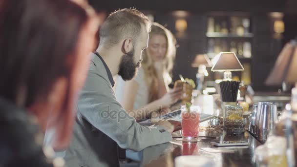 20s barbudo hipster hombre está coqueteando con chica rubia en un bar de noche — Vídeo de stock