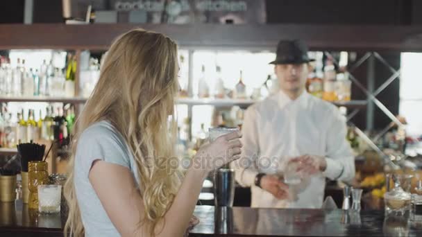 Barman profissional trata coquetel para uma menina loira em um bar — Vídeo de Stock