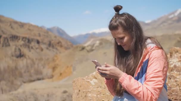 20s ομορφιάς γυναίκα χρησιμοποιώντας το smartphone σε εξωτερικούς χώρους με πάγο βουνά στο φόντο — Αρχείο Βίντεο