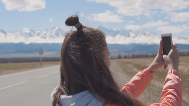 Punto de vista manos de la mujer de 20 años está tomando fotos en el teléfono inteligente móvil con picos de hielo y carretera en backgroung — Vídeos de Stock