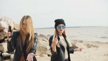 Plaj yakın çekim yavaş hareket üzerinde iki çekici sarışının dökülmek.