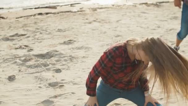 Jonge blonde is dansen op het zandstrand op haar knieën slow-motion. — Stockvideo