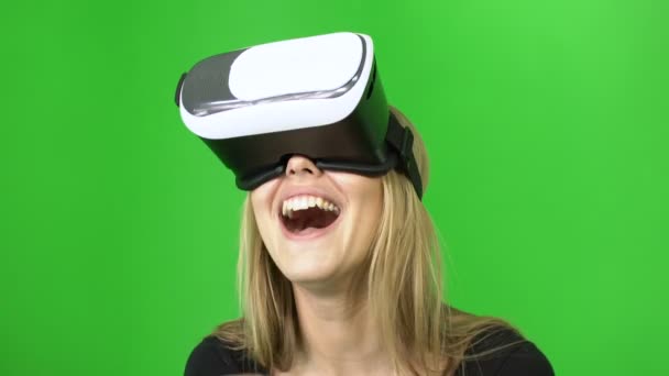 20s donna attraente che indossa in VR casco è ridere e agitando le mani toching dietro, verde croma sfondo chiave — Video Stock