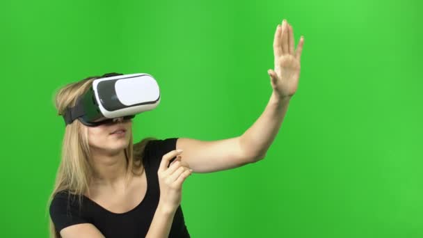 Mujer rubia de 20 años que se divierten, disfrutar de usar casco gafas VR sobre un fondo verde — Vídeo de stock