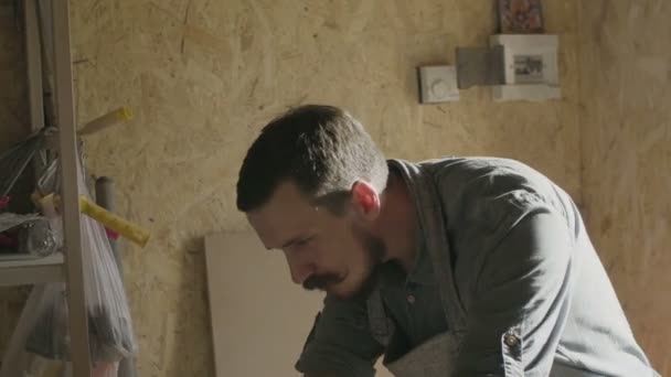 Konsantre woodworker portresi. 20'li yaşlarda iş onun atölyesinde makinede ahşap tahta ile marangoz — Stok video