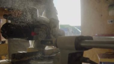 Portre konsantre 20s woodworker daire testere kullanarak önlük sakallı. Testere ahşap tahta arka plan üzerinde talaş ile eller