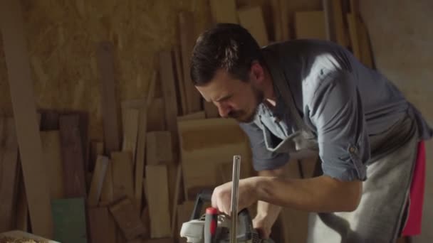 20s γενειοφόρος ξυλουργός λειτουργεί με brashing μηχάνημα σε ηλιόλουστη μέρα σε εργαστήριο — Αρχείο Βίντεο