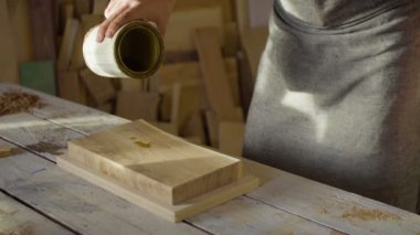 Bir ahşap tahta üzerinde cila dökme marangoz woodworker elinde