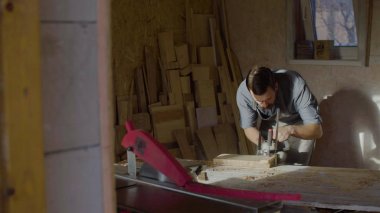 20'li yaşlarda woodworker işleri brashing makine ile güneşli gün atölyede sakallı