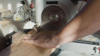 Marangoz negatif ahşap tahta daire testere kullanarak ellerini kapatın. uçan talaş