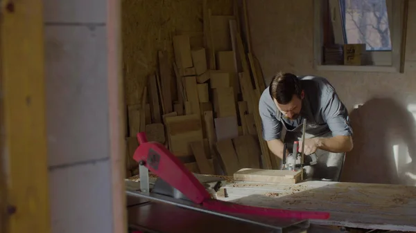 20'li yaşlarda woodworker işleri brashing makine ile güneşli gün atölyede sakallı