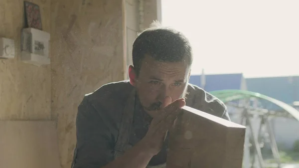 Konsantre woodworker portresi. 20'li yaşlarda iş onun atölyesinde makinede ahşap tahta ile marangoz