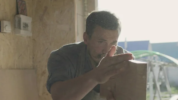 Konsantre woodworker portresi. 20'li yaşlarda iş onun atölyesinde makinede ahşap tahta ile marangoz