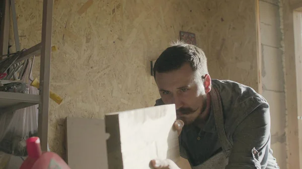 Konsantre woodworker portresi. 20'li yaşlarda iş onun atölyesinde makinede ahşap tahta ile marangoz