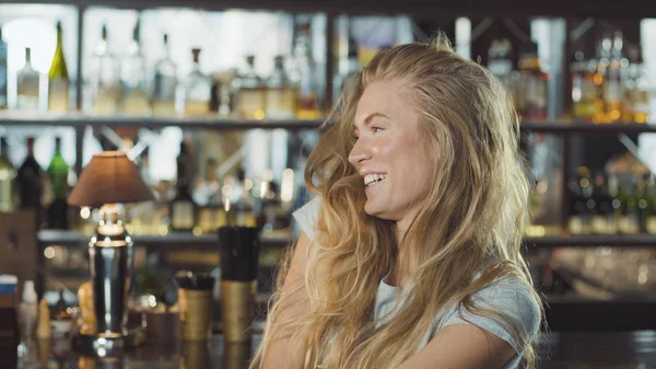 Abiye yakınındaki tezgahın oturuyor ve kameraya bakarak güzel sarışın kadın