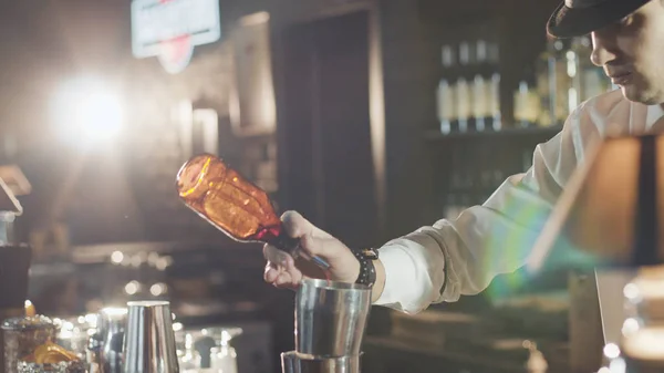Barman v klobouku se připravuje koktejl v baru — Stock fotografie