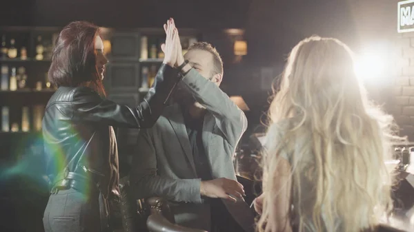 Gece barda konuşuyor arkadaş şirket. Kızıl saçlı kadın beşlik sakallı onun arkadaşı veriyor içinde bar, sonra onlar gözlük birlikte tıklatması.