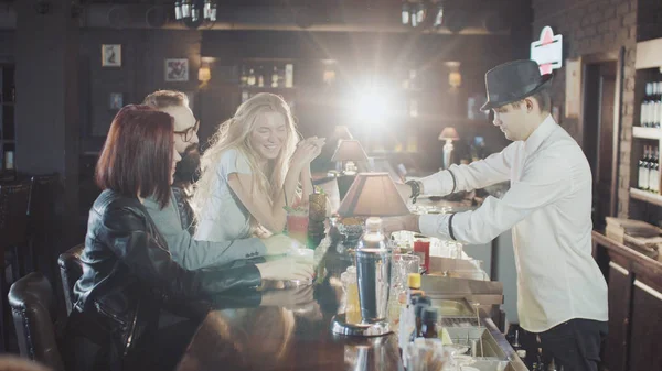 şirket barmen şapkalı arkasında içecekler gece parti bardaki hazırlanıyor iken 20'li yaşlarda dring kokteyller arkadaşız