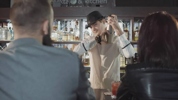 20s бармен готує коктейль з шейкером за гостями — стокове фото