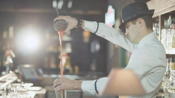 Le barman au chapeau prépare un cocktail au bar — Photo