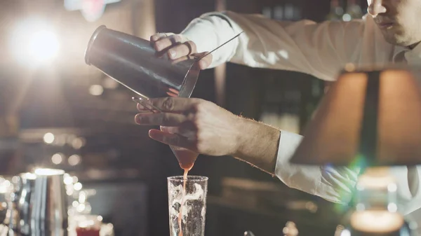 Barkeeper mit Hut bereitet Cocktail in Bar zu Stockbild