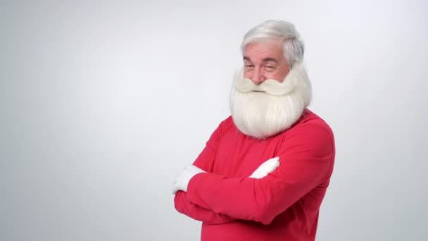 Vánoční stařík s bradkou v červeném klobouku, mrkající a ukazující prstem na kameru. Santa Claus legrační parodie na bílém pozadí — Stock video