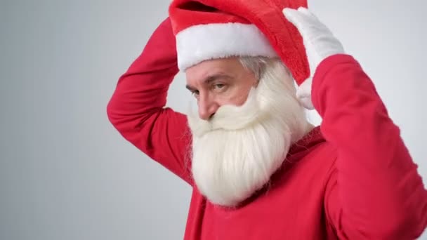 Retrato de un hombre guapo vestido como Papá Noel sobre un fondo blanco — Vídeos de Stock