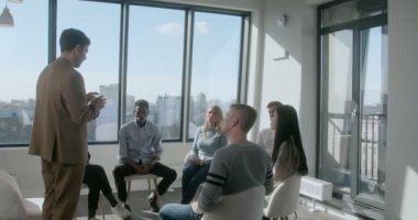 Takım elbiseli bir iş adamı, genç bir melez grubu selamlıyor.