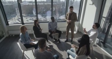 Genç ve kendine güvenen koçun çok ırklı öğrencilerle yaptığı görüşmelere üst düzey bakış