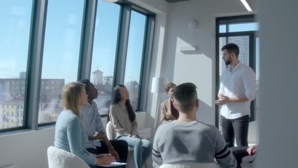 Guapo entrenador masculino hablando con un equipo de carreras mixtas — Vídeo de stock