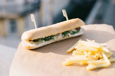 Kafenin yaz terasında sandviç ve patates kızartması.