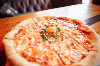 Samimi bir kafedeki ahşap bir masada Carbonara pizzası.