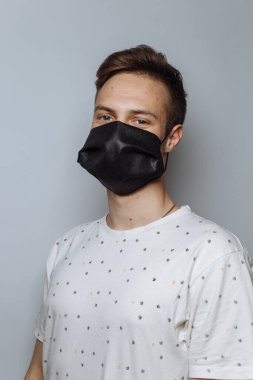 young guy in a medical mask on a white background, copy space