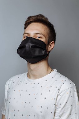 young guy in a medical mask on a white background, copy space