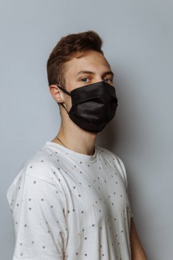 young guy in a medical mask on a white background, copy space
