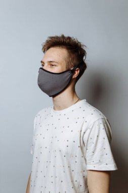 young guy in a medical mask on a white background, copy space