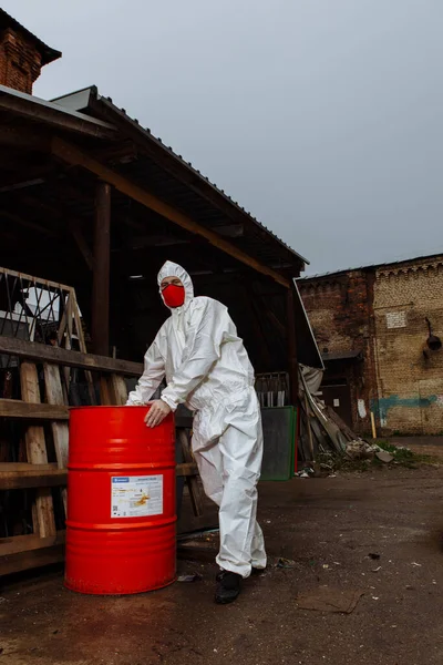 man in protective suit, red medical mask and latex gloves during a coronavirus COVID-19 pandemic in the ruins of the city