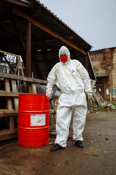 man in protective suit, red medical mask and latex gloves during a coronavirus COVID-19 pandemic in the ruins of the city