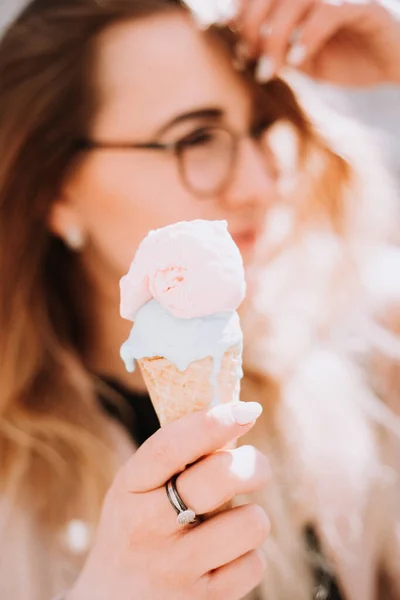 beautiful girl eating an ice cream outdoors on spring